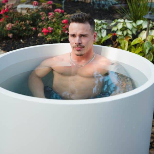 Man relaxing in outdoor soaking tub.