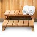 Wooden sauna bench with white towels.