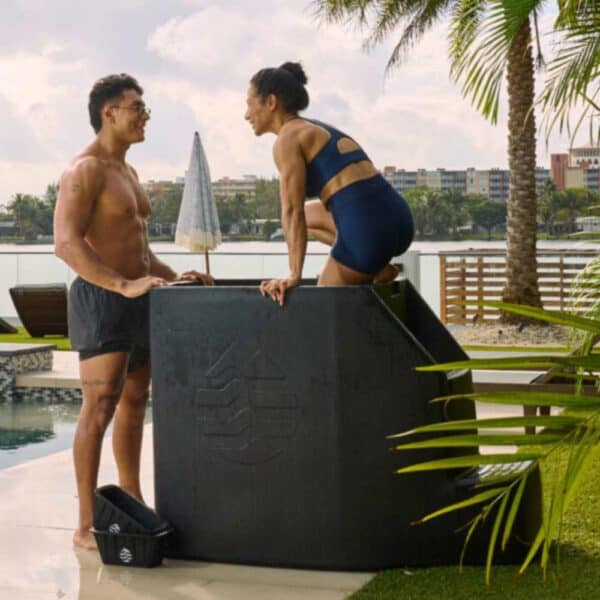 woman in Ice barrel 500 plunge tub with man watching