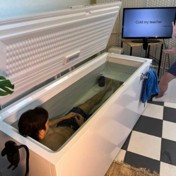 Person in ice bath therapy with motivational quote screen.